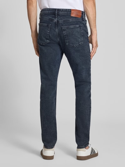 Männermodel trägt dunkelblaue Tapered Fit Jeans aus Baumwoll-Mix Modell 'EVEREST' von Calvin Klein Jeans, Herren Jeans, Ganzkörperansicht Rückansicht.