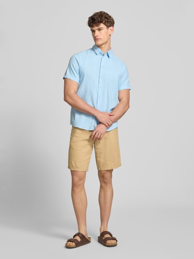 Męski model nosi Shorts aus Leinen-Viskose-Mix Modell 'MALVIN' od Blend w kolorze beżowym, krój regular fit, elastyczny pas, kieszenie, szerokość w rozmiarze M: 37 cm, długość nogawki wewnętrznej w rozmiarze M: 23 cm, pełen widok z przodu.