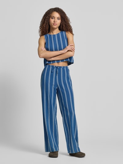 Frauenmodel trägt Wide-Leg-Pants mit elastischem Bund und Kordelzug von Jake*s Casual aus Reiner Baumwolle, ausgestellter Schnitt, blaue Farbe mit weißen Streifen, französische Eingrifftaschen, Gesäßtaschen, Ganzkörperansicht von vorne.