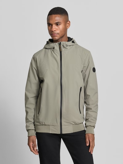 Męski model nosi kurtkę Jacke mit Reißverschlusstaschen Modell 'MATTEO' von CARS JEANS, mieszanka materiałów z dodatkiem streczu, krój regular fit, kolor beżowy, czarne zamki błyskawiczne, kaptur z tunelem, kieszenie zapinane na zamek błyskawiczny, długość tyłu w rozmiarze M: 70 cm, szerokość ramion w rozmiarze M: 44 cm, szerokość w rozmiarze M: 50 cm, długość rękawów w rozmiarze M: 70 cm, gładka faktura, widok całej sylwetki z przodu.