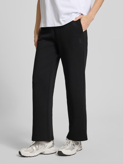 Frauenmodel trägt schwarze Sweatpants mit elastischem Bund und Logo-Print von ARMANI EXCHANGE, Straight Fit, seitliche Eingrifftaschen, Ganzkörperansicht von vorne.