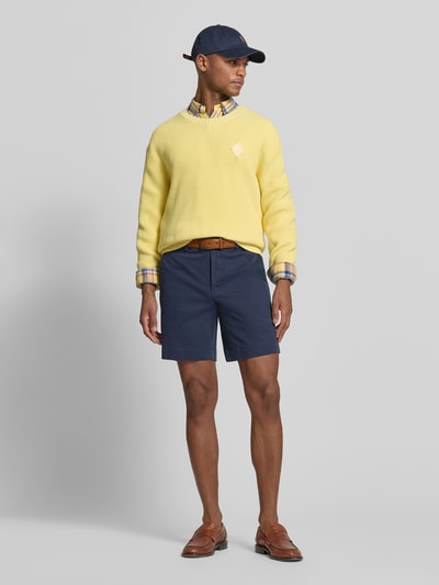 Męski model nosi Straight Fit Chinoshorts aus Baumwoll-Mix von Polo Ralph Lauren, jednokolorowy, detal z logo, szlufki na pasek, kieszenie boczne i tylne, mieszanka bawełny, pełna sylwetka z przodu.