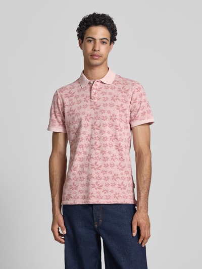 Männermodel trägt Slim Fit Poloshirt mit kurzer Knopfleiste Modell 'FRISCO' von Blend, reine Baumwolle, blassrosa mit floralem Muster, Ganzkörperansicht von vorne.