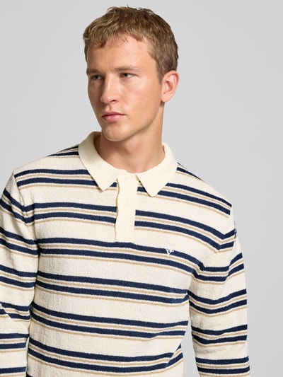 Männermodel trägt Strickpullover mit Polokragen in Bouclé-Optik von REVIEW im Streifenmuster, Nahaufnahme Oberkörper.