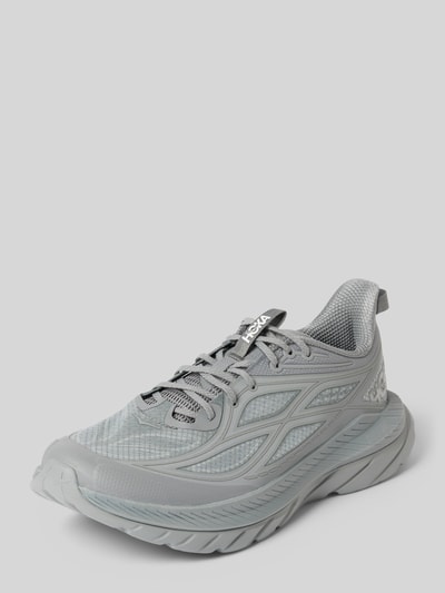 Produktfoto, Sneaker mit Label-Details und profilierter Sohle von HOKA in Hellgrau, abgerundete Form, Schnürverschluss, strukturierte Oberfläche