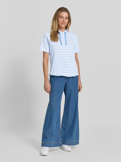 Modelka kobieca nosi Relaxed Fit Sweatshirt mit Kapuze und 1/2-Arm od Smith and Soul, biało-niebieskie paski, czysta bawełna, allover look, krótki rękaw, widok całej sylwetki z przodu.