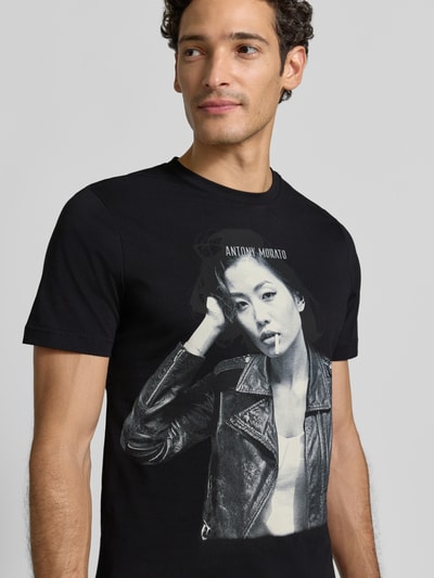 Männermodel trägt schwarzes Regular Fit T-Shirt aus reiner Escorial-Wolle von Antony Morato mit Label-Print, Nahaufnahme Oberkörper.