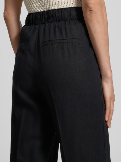 Vrouwenmodel draagt Relaxed Fit Weite Hose aus Leinen-Viskose-Mix van s.Oliver RED LABEL, uni zwart, elastische tailleband, steekzakken, detailopname rug.