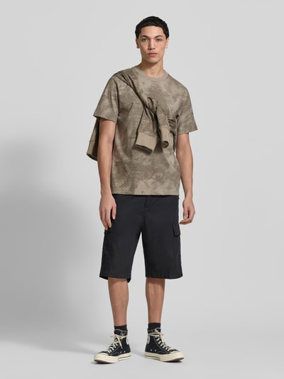 Männermodel trägt T-Shirt aus Baumwolle mit Rundhalsausschnitt von G-Star Raw im Allover-Look, Regular Fit, dezente Muster, Ganzkörperansicht von vorne.