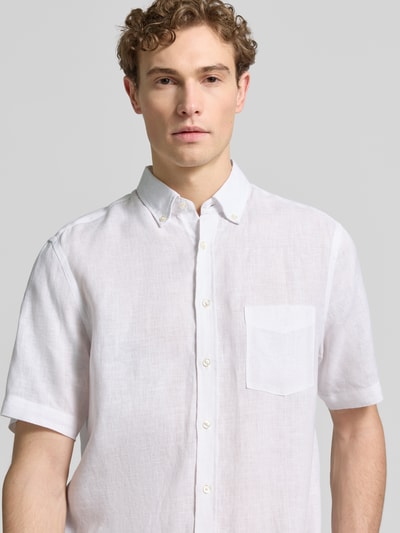 Männermodel trägt Regular Fit Freizeithemd aus Leinen von Christian Berg Men, wit, korte mouwen, borstzak, button-down kraag, knoopsluiting, pure linnen, voorkant bovenlichaam close-up.