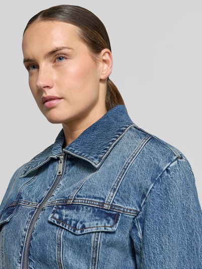 Frauenmodel trägt Jeansjacke aus Baumwoll-Mix Modell 'Melu' von Gestuz in Blau mit Umlegekragen und Zweiwege-Reißverschluss, Nahaufnahme Oberkörper.
