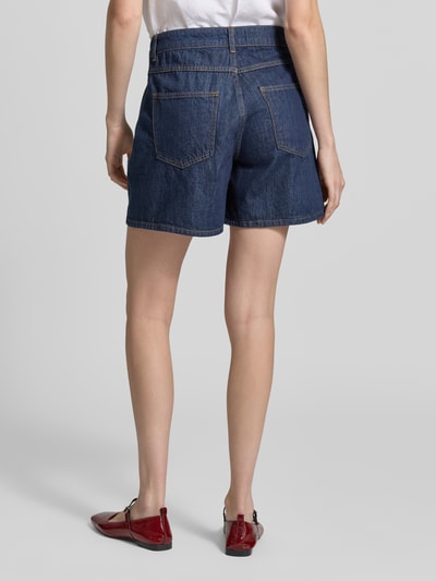 Frauenmodel trägt Jeansshorts mit Eingrifftaschen von Rich & Royal, dunkelblaue Baumwolle, Regular Fit, Detailaufnahme Rückansicht. Bundweite 37 cm, Innenbeinlänge 14 cm.