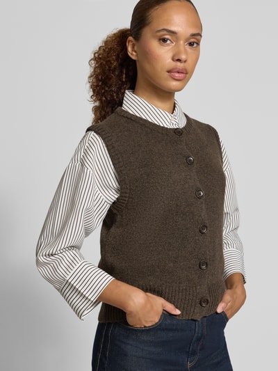 Frauenmodel trägt Regular Fit Strickweste aus Woll-Mix von Christian Berg in Braun mit Knopfleiste und gerippten Abschlüssen, Damen Strickweste, Woll-Mix, ärmellos, Rückenlänge 45 cm, Ganzkörperansicht von vorne.
