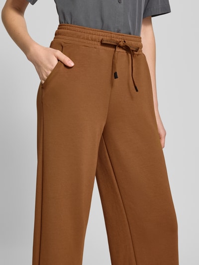 Kobiece model prezentuje spodnie dresowe Wide Fit Sweatpants in verkürzter Passform Modell 'Banu' od Soyaconcept, elastyczna mieszanka materiałów z domieszką modalu, krój wide fit, skrócony, pas z tunelem; zbliżenie na górną część ciała