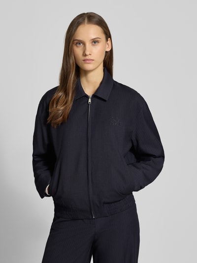 Frauenmodel trägt Lässige Blousonjacke mit Nadelstreifen von Review, dunkelblauer Material-Mix mit Viskose-Anteil, Relaxed-Fit, Leistentaschen, Reißverschluss, Ganzkörperansicht von vorne.