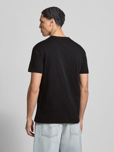 Männermodel trägt Regular Fit T-Shirt aus reiner Baumwolle von Tommy Jeans, Optik: Unifarben, Materialverarbeitung: Jersey, Ganzkörperansicht Rückansicht.