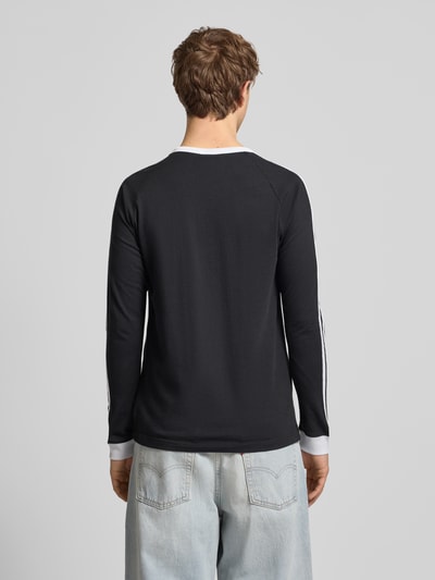Männermodel trägt Longsleeve mit gerippten Abschlüssen von adidas Originals aus reiner Baumwolle, Regular-Fit, Ganzkörperansicht Rückansicht.
