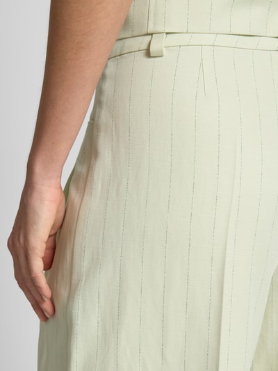Frauenmodel trägt Loose Fit Weite Hose mit Leinen-Anteil Modell 'TAKORA' von BOSS Orange, Optik:Allover-Muster, Nadelstreifen-Muster, Bundfalte, Gürtelschlaufe, Eingrifftasche, Materialverarbeitung: Twill, Lyocell-Baumwolle-Leinen-Mix, Nahaufnahme Oberkörper.