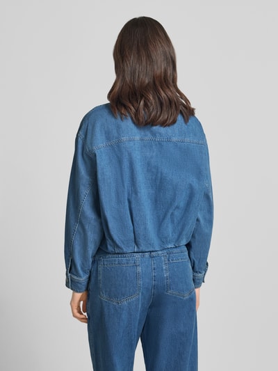 Frauenmodel trägt Jeansjacke mit Brusttaschen Modell 'Imke' von JOOP!, niebieska bawełna, krój relaxed fit, kołnierzyk koszulowy, listwa guzikowa, długość tyłu w rozmiarze 36: 54 cm, szerokość ramion w rozmiarze 36: 54 cm, szerokość klatki piersiowej w rozmiarze 36: 60 cm, długość rękawów w rozmiarze 36: 52 cm, tekstura gładka, widoczne przeszycia, całość w jednym kolorze, całkowita sylwetka z tyłu