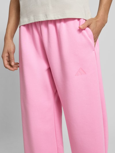 Frauenmodel trägt Loose Fit Sweatpants mit Baumwoll-Anteil von adidas Sportswear in Optik: Unifarben, Label-Patch, Sweat, Nahaufnahme Oberkörper.