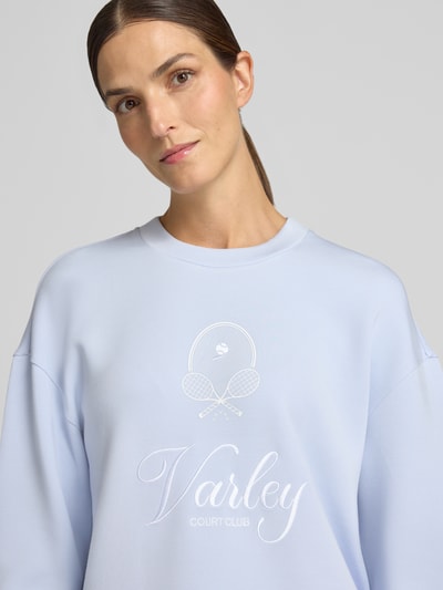 Frauenmodel trägt Sweatshirt aus Viskose-Mix Modell 'rasco' von VARLEY in Hellblau mit Label-Stickerei, Nahaufnahme Oberkörper.
