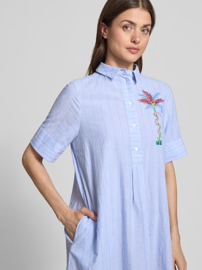 Frauenmodel trägt knielanges Hemdblusenkleid mit Motiv-Print von Milano Italy aus reiner Baumwolle, gerader Schnitt, 1/2-Arm, Nahaufnahme Oberkörper.