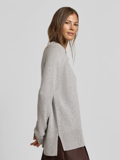 Frauenmodel trägt Regular Fit Pullover aus reinem Kaschmir in Strick-Optik von MYON, hellgrau, Rundhalsausschnitt, Seitenansicht, Nahaufnahme Oberkörper.