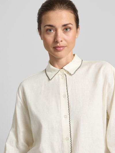 Vrouwenmodel draagt Leinenbluse mit Ziernaht und Kentkragen van Christian Berg Woman Selection in lichte crèmekleur, straight fit van linnen-viscose mix, knoopsluiting en siernaad, bovenlichaam close-up.
