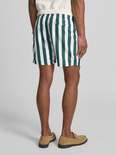 Männermodel trägt Badehose mit Gesäßtasche und elastischem Bund von Shiwi, gestreift, Regular-Fit, Allover-Look, Ganzkörperansicht Rückansicht.