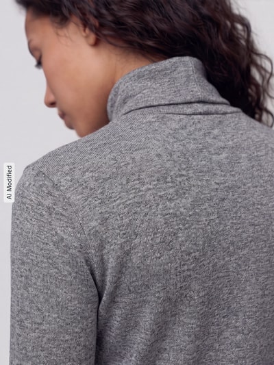 Vrouwenmodel draagt Slim Fit Langarmshirt uit lyocellmix van Jake*s Casual, fijne grijze textuur, detailopname rug, KI-modified beeld.