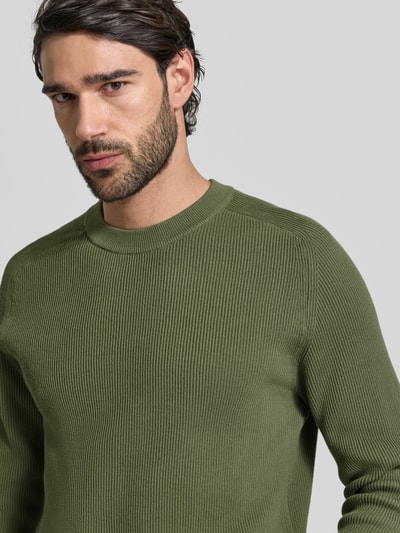 Männermodel trägt Slim Fit Pullover in Strick-Optik Modell 'Nordin' von Casual Friday in Grün, reine Baumwolle, Nahaufnahme Oberkörper.