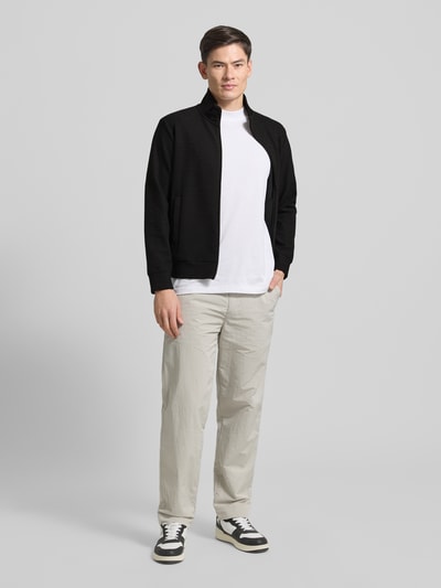 Männermodel trägt schwarze Sweatjacke mit Stehkragen von Emporio Armani im Baumwoll-Lyocell-Mix, Lockerer-Schnitt, Eingrifftaschen, Ganzkörperansicht von vorne.