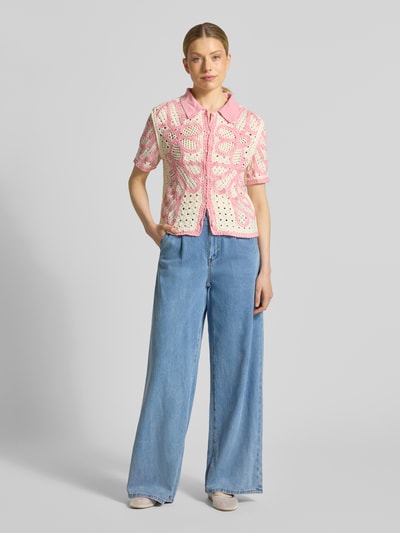 Frauenmodel trägt Jeans mit elastischem Bund und Eingrifftaschen Modell 'RUDY' von SUNCOO PARIS, Lyocell-Baumwoll-Mix, Wide Leg, helle blaue Farbe, glatte Textur, kombiniert mit gehäkeltem rosa-beigem Oberteil, Ganzkörperansicht von vorne.
