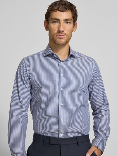 Männermodel trägt Regular Fit Business-Hemd aus Baumwolle von Christian Berg Men, blau-weiß gestreift, Haifischkragen, Nahaufnahme Oberkörper.
