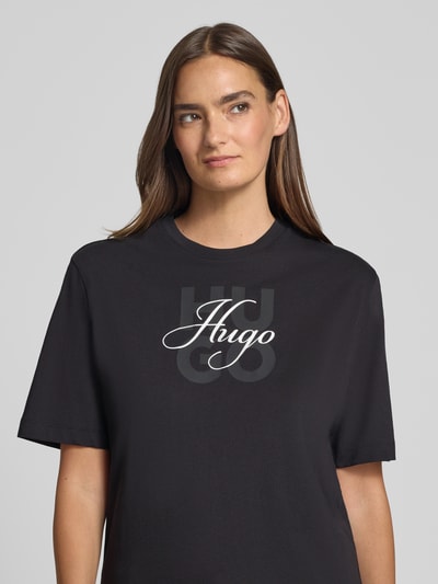 Kobieta prezentuje damski t-shirt Regular Fit T-Shirt aus reiner Baumwolle Modell 'Dashire_5' von HUGO w kolorze czarnym, nadruk z logo, damski t-shirt od HUGO, zbliżenie na górną część ciała