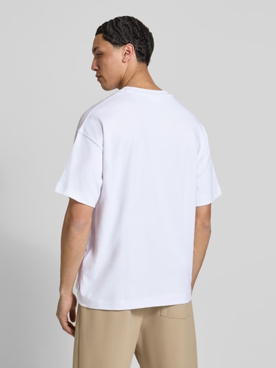 Männermodel trägt wit T-shirt met ronde hals model 'BARRON' van Jack & Jones, katoenmix met stretch, regular fit, ruglengte maat M 69 cm. Ganzkörperansicht Rückansicht