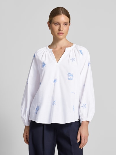 Frauenmodel trägt Regular Fit Tunikabluse mit Stitchings und V-Ausschnitt von Oui aus Reine Baumwolle in Weiß mit blauen Stickereien, Ganzkörperansicht von vorne. Rückenlänge bei Größe 36: 66 cm, Ärmellänge: 59 cm.
