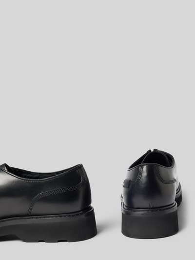 Produktfoto, Halbschuhe aus echtem Leder Modell 'Derby' von Woolrich in Schwarz mit abgerundeter Passform, sichtbarem Logo-Detail, strukturierter Gummisohle, Absatzhöhe 4 cm, Schafthöhe 7 cm, Schaftweite 11 cm, glatte und matte Texturen auf hellem Hintergrund.