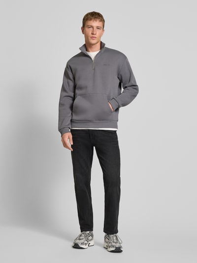 Männermodel trägt Straight Fit Jeans im Five-Pocket-Design von REVIEW in schwarzer Waschung, Baumwoll-Elasthan-Mix, Ganzkörperansicht von vorne.
