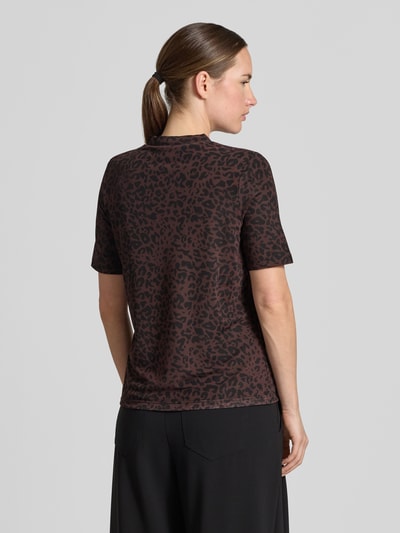 Frauenmodel trägt T-Shirt mit Leo-Print von MORE & MORE, braun-schwarzer Material-Mix, Stehkragen, gerader Schnitt, Ganzkörperansicht Rückansicht.