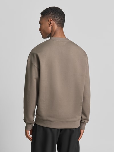 Männermodel trägt Regular Fit Sweatshirt aus reiner Baumwolle Modell 'DAYLO' von HUGO, Optik: Unifarben, Label-Applikation, Ganzkörperansicht Rückansicht.