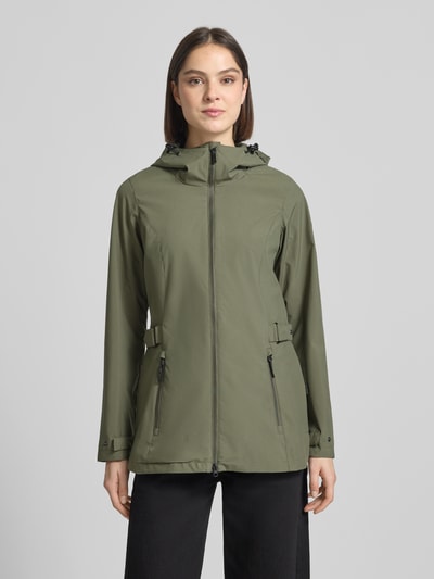 Frauenmodel trägt Regular Fit Regenmantel mit Logo-Detail von G.I.G.A. DX in Olivgrün, Zweiwege-Reißverschluss, Kapuze mit Tunnelzug, Eingrifftaschen; Rückenlänge 76 cm, Schulterbreite 40 cm, Brustweite 50 cm, Ärmellänge 66 cm; Ganzkörperansicht von vorne.