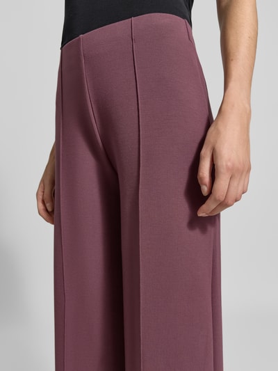 Männermodel trägt Wide Fit Hose mit Ziernähten von Christian Berg Woman, elastyczna mieszanka materiałów z modalem, ozdobne szwy, elastyczny pas, zbliżenie na biodra