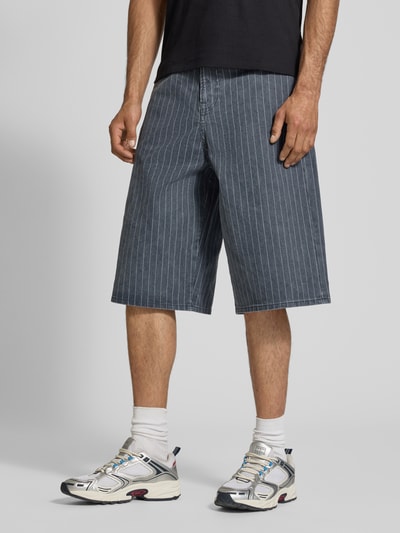 Männermodel trägt Shorts im Allover-Look Modell 'OWEN' von Jack & Jones aus reiner Baumwolle, relaxed Fit, Ganzkörperansicht von vorne.