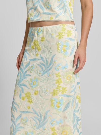 Frauenmodel trägt Midirock mit Allover-Pailettenbesatz von BAUM & PFERDGARTEN im floralen Design, Elastischer-Material-Mix, Regular-Fit, Nahaufnahme Oberkörper.