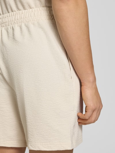 Männermodel trägt Shorts mit Logo-Stitching von PUMA PERFORMANCE aus reiner Baumwolle, Strukturmuster, Nahaufnahme Oberkörper.