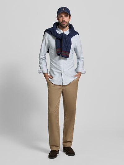 Mannelijk model draagt slim fit vrijetijdsoverhemd uit puur katoen model 'OXFORD' van Polo Ralph Lauren in lichtblauw met button-downkraag, doorlopende knoopsluiting, labelstitching en lange mouwen, ruglengte maat M 79 cm, schouderbreedte 43 cm, mouwlengte 66 cm, geheelopname vooraan.