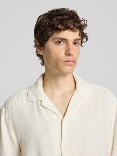 Männermodel trägt Regular Fit Freizeithemd aus Viskose-Leinen-Mix Modell 'LATHAM' von Only & Sons, cremefarben, Strukturmuster, Nahaufnahme Oberkörper.