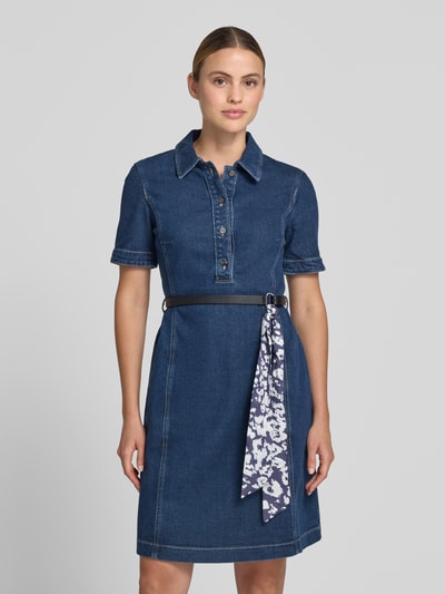 Frauenmodel trägt knielanges Jeanskleid mit Gürtel von Marc Cain, Dunkelblau, taillierter Schnitt, Baumwoll-Lyocell-Anteil, Hemdblusenkragen, Knopfleiste, Ganzkörperansicht von vorne.