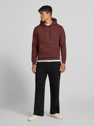 Männermodel trägt Straight Fit Sweatpants mit elastischem Bund von JACK & JONES, schwarze Hose mit Eingrifftaschen, Ganzkörperansicht von vorne. Material-Mix mit Baumwoll-Anteil, Innenbeinlänge bei Größe M 76 cm.